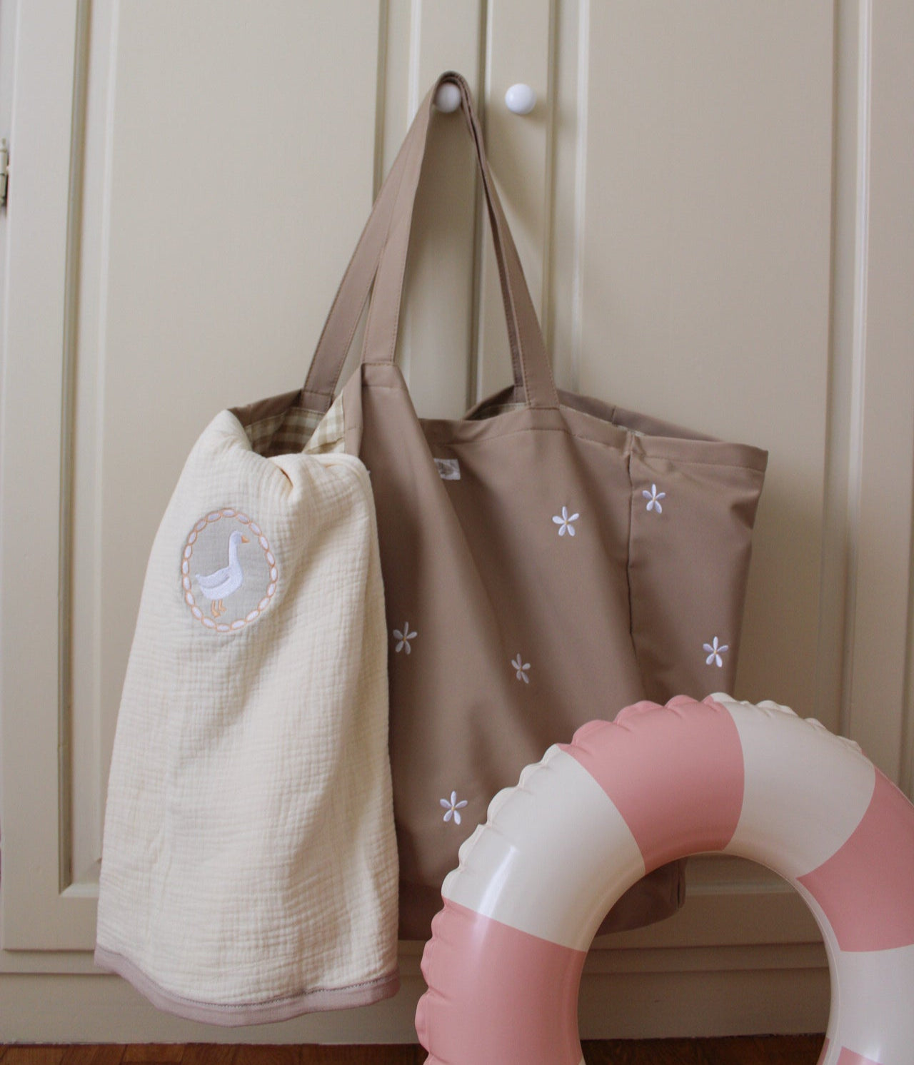 coperta in mussola miliblum con borsa mare daisy di miliblum e salvagente rosa