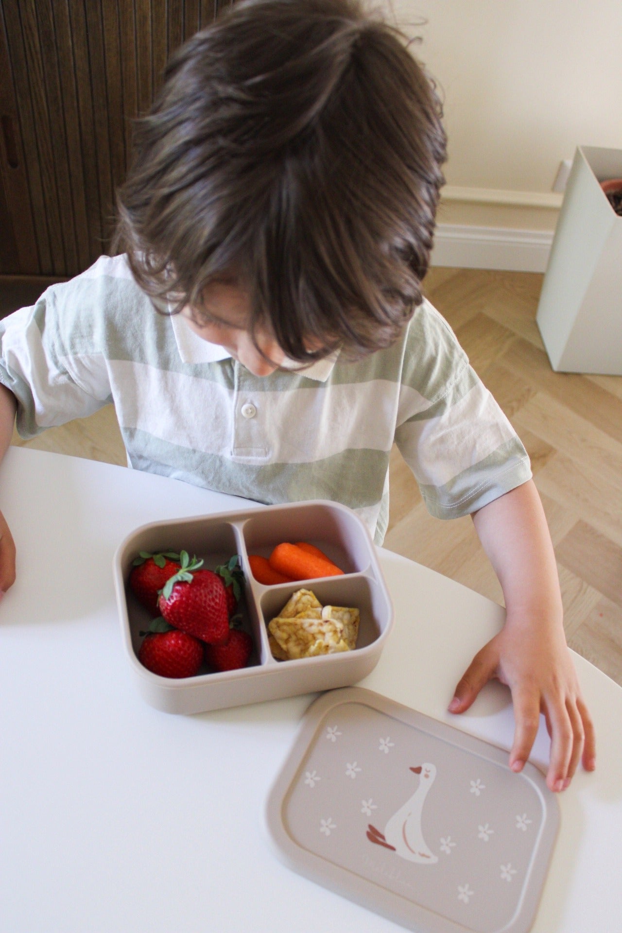 bimbo guarda felice la merenda salutare dentro la lunchbox miliblum