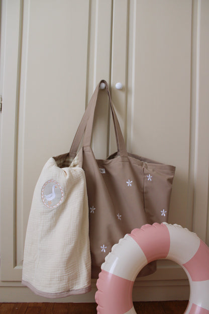 dettaglio borsa mare daisy di miliblum con copertina in mussola di cotone ricamo oca milly e salvagente rosa