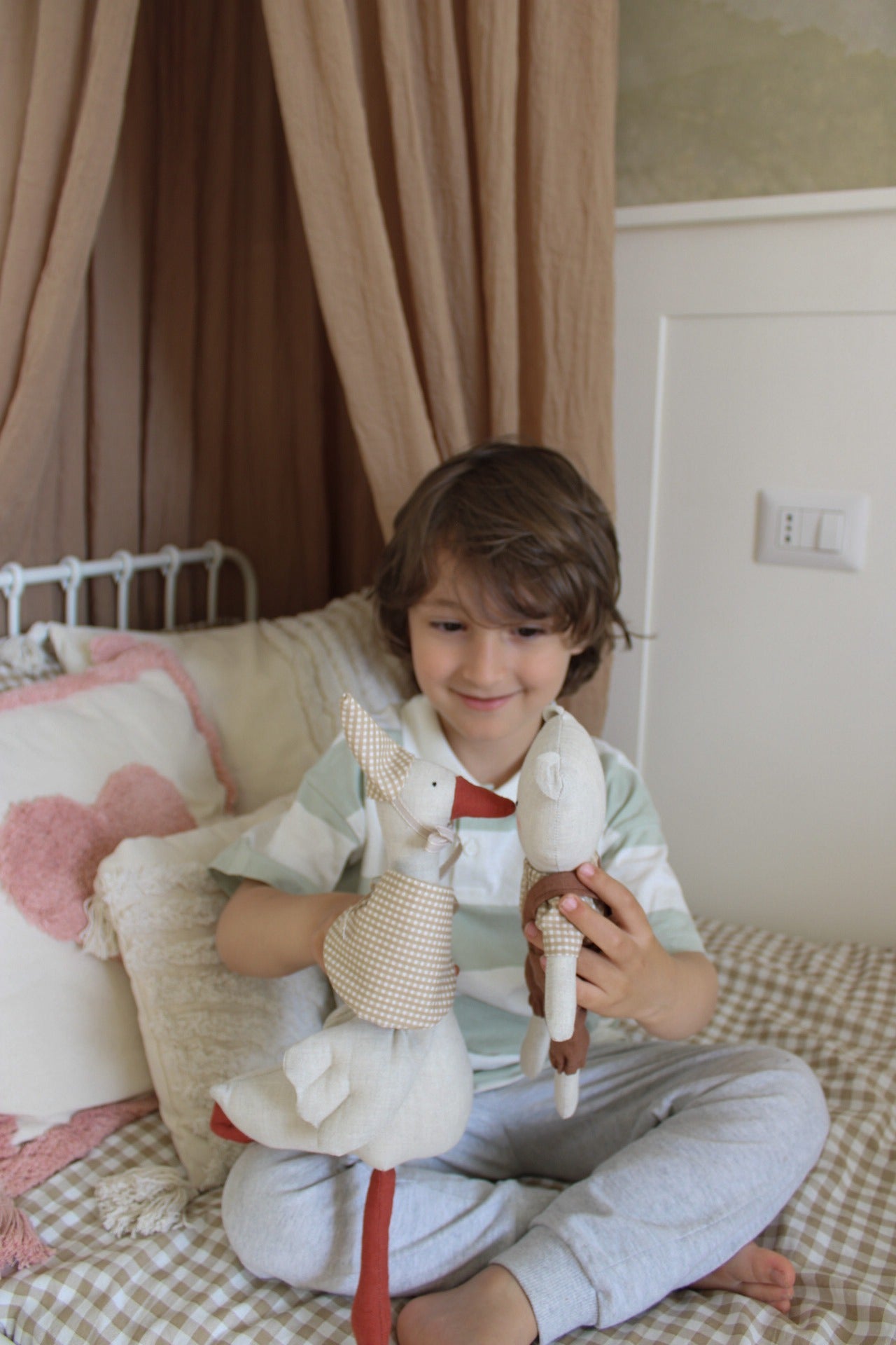 bambino gioca felice con milly e lou pupazzi artigianali oca e orso miliblum